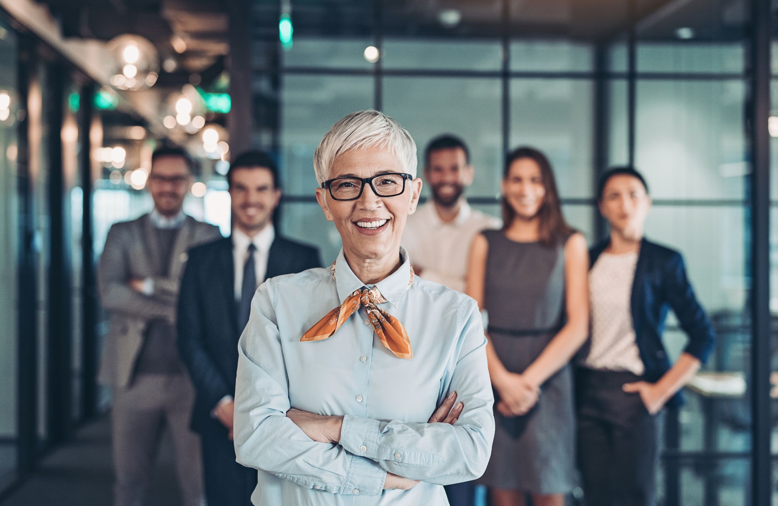 Confident woman standing with a diverse professional team